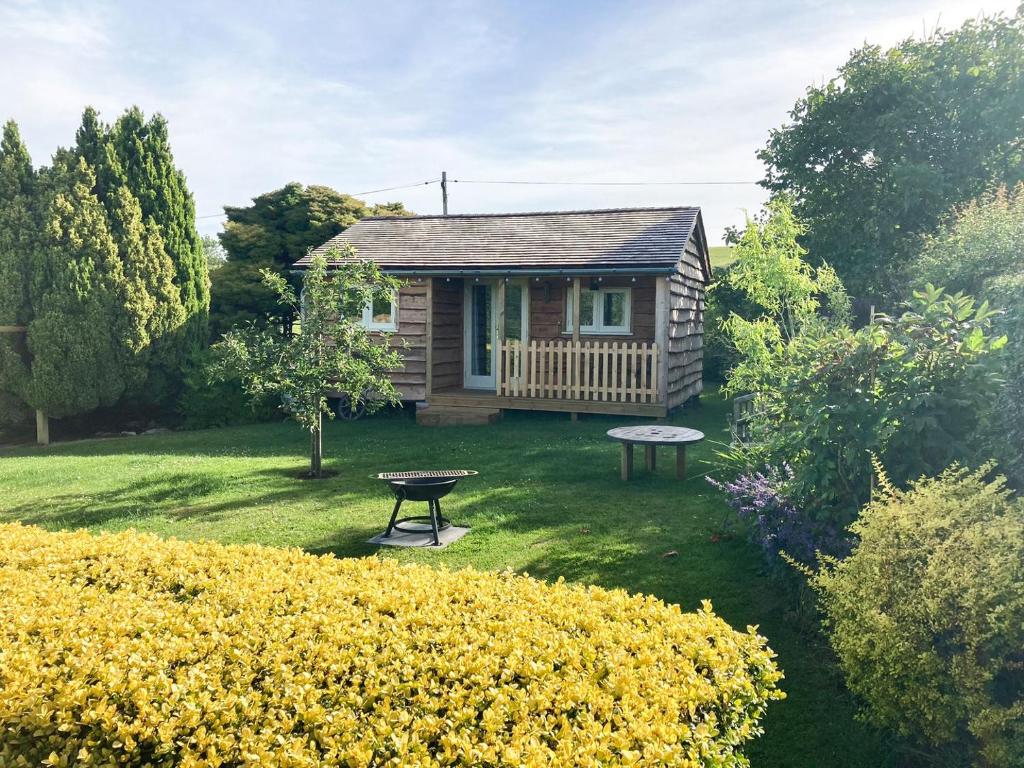 uma pequena casa com uma mesa de piquenique num quintal em Walnut Lodge em Wells