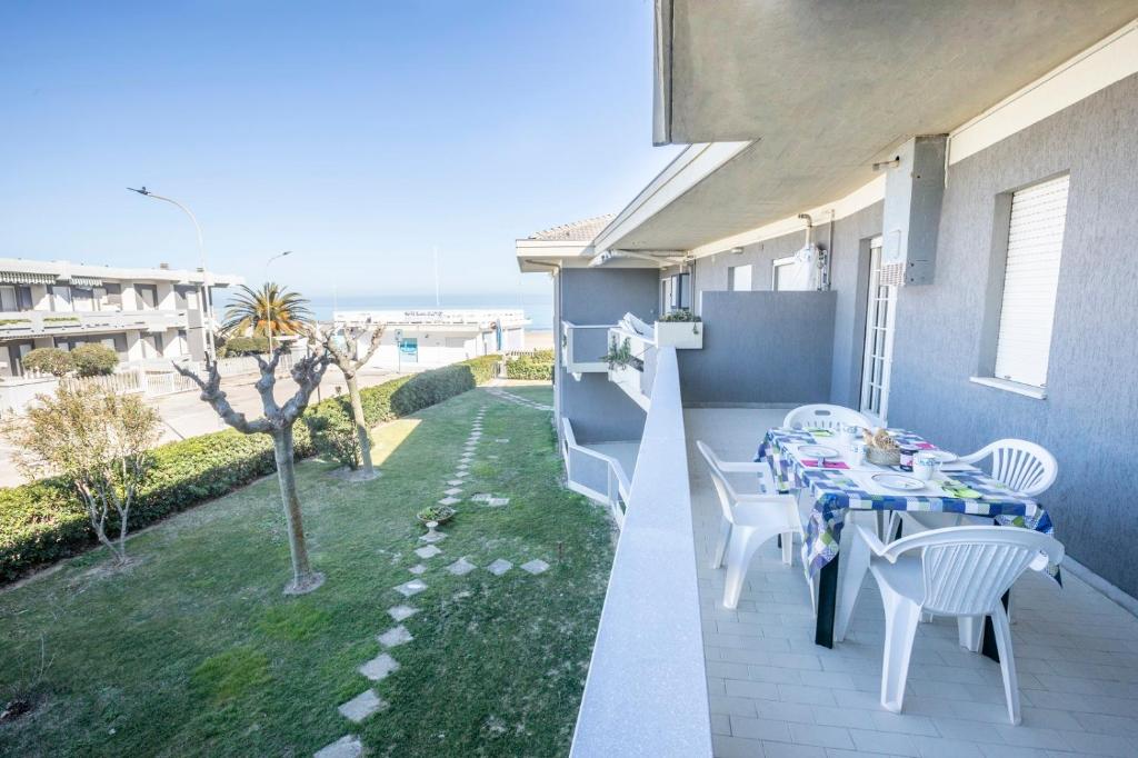 a table and chairs on a balcony with a view of the ocean at Green Marine B09 Silvi Vacanza in Silvi Marina