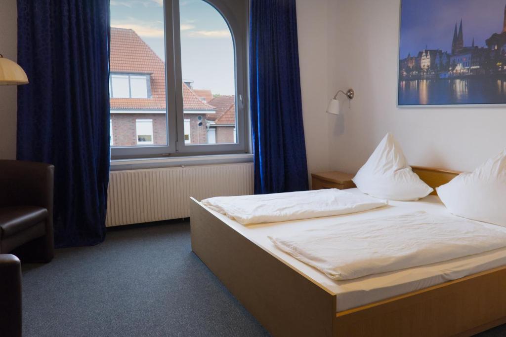 a bedroom with a bed and a large window at Haus Magdalene in Bad Schwartau