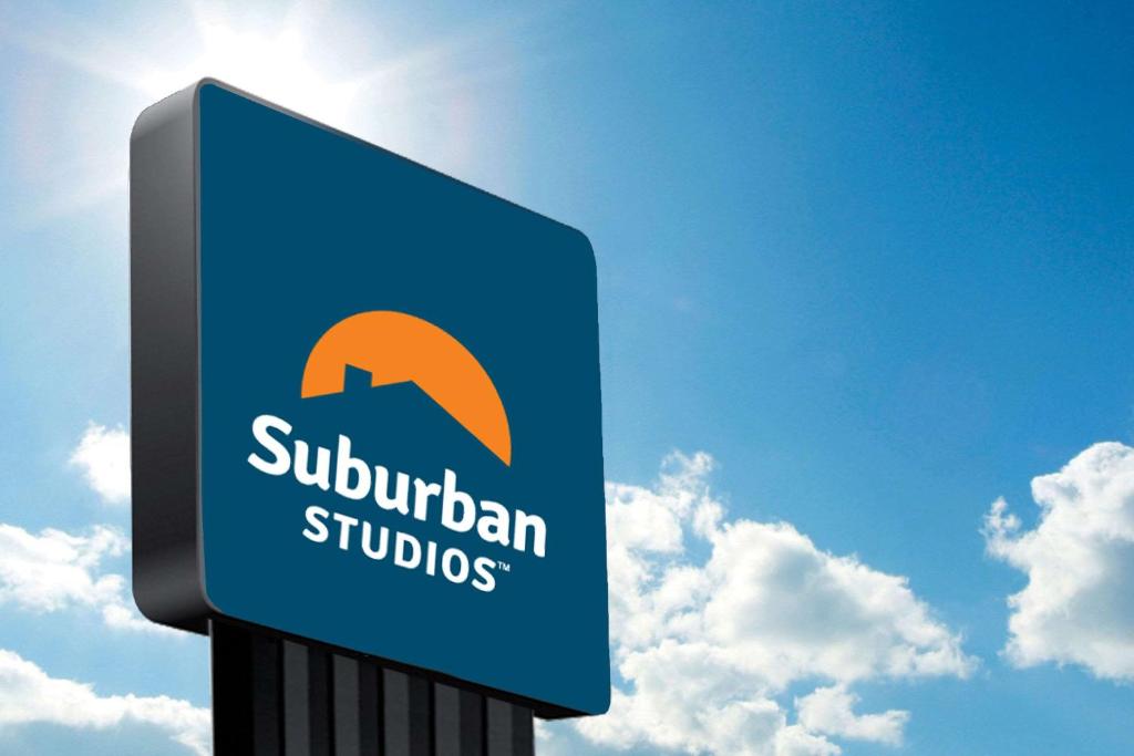 a blue sign for a suburban studios at Suburban Studios Fort Smith in Fort Smith