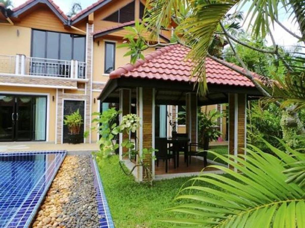 a house with a swimming pool in front of it at Private Villas Bangtao in Bang Tao Beach