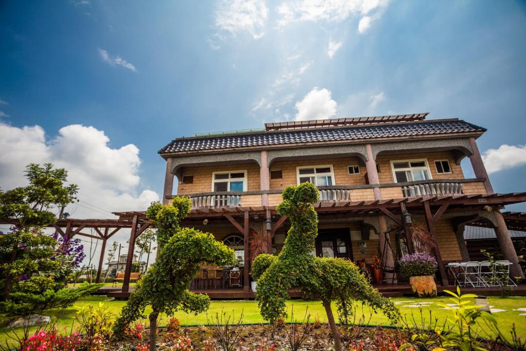a large wooden house with a tree at Zhuyuan Ju B&B in Yuanshan