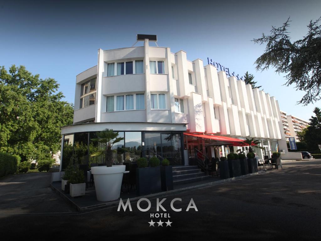 a white building with a sign in front of it at Le Mokca in Meylan