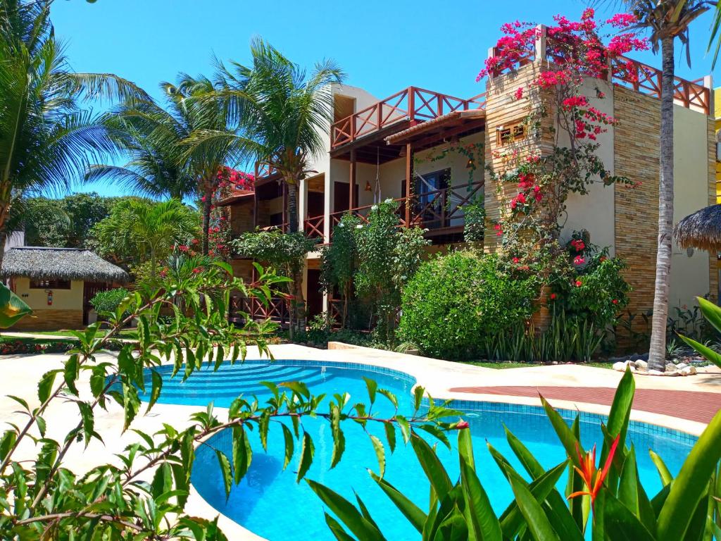 a resort with a swimming pool in front of a building at Serrote Apartamento in Jericoacoara