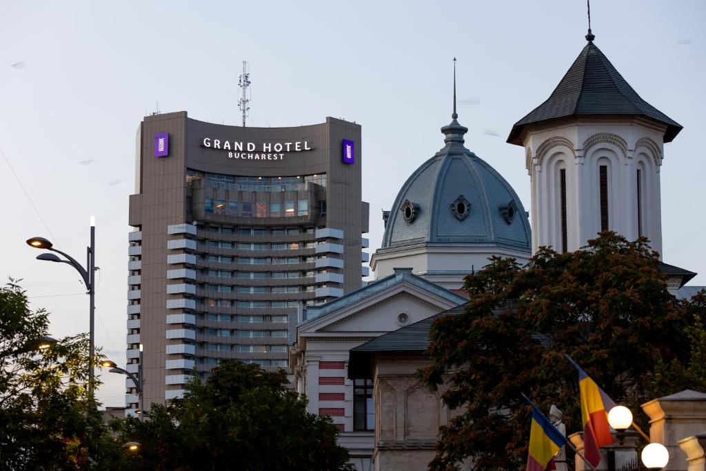 a group of tall buildings in a city with a sign at Grand Hotel Bucharest in Bucharest