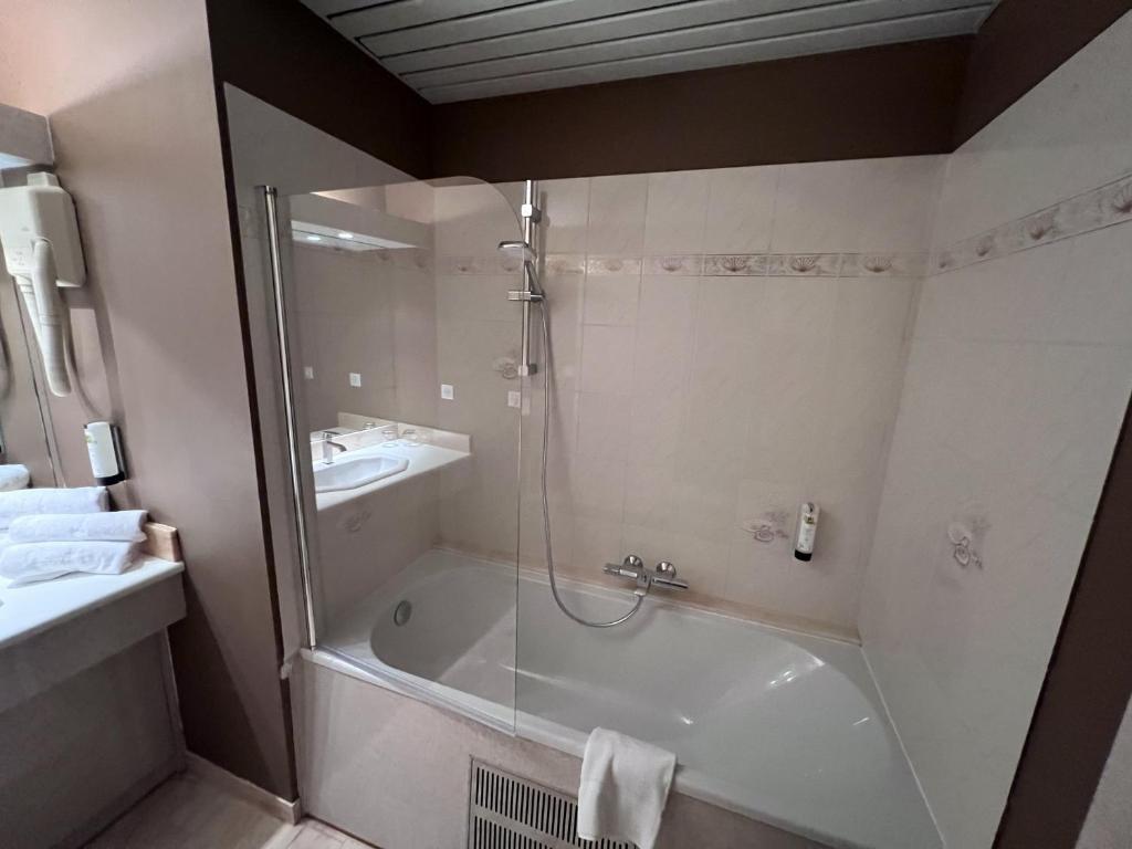 a bathroom with a shower and a tub and a sink at Logis Hôtel Spa la Poste in Vitry-le-François