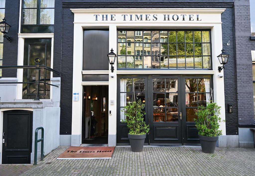un front de magasin avec deux plantes en pot devant lui dans l'établissement The Times Hotel, à Amsterdam