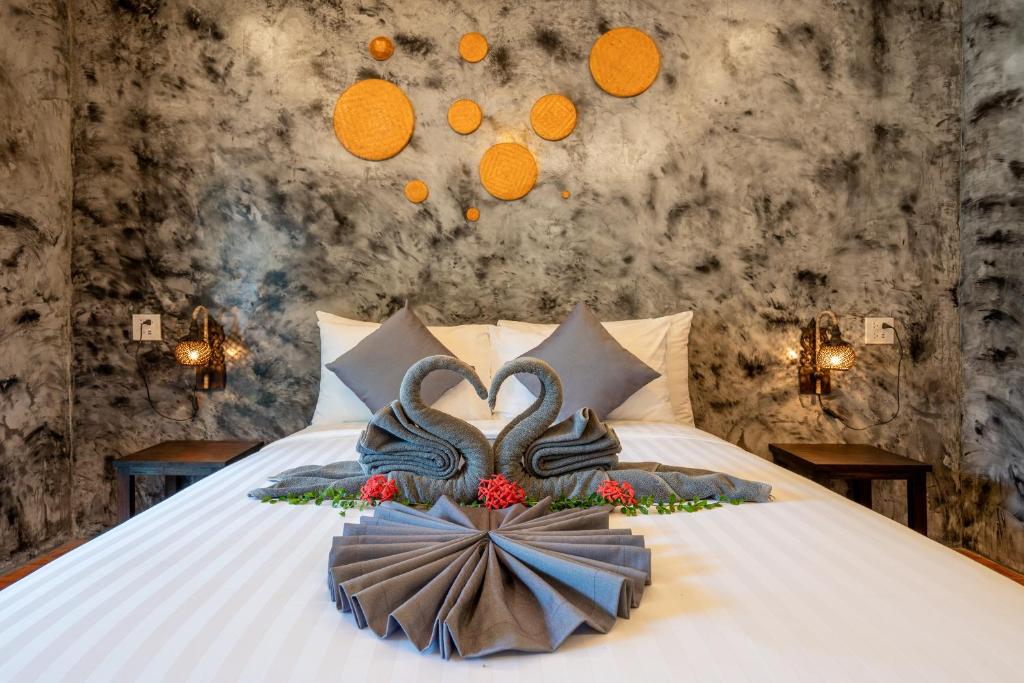 a bed with two swans on it in a room at El Matcha Lanta Resort in Phra Ae beach