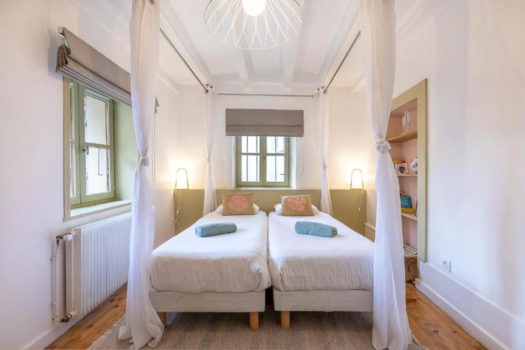 una camera con due letti con tende e un lampadario a braccio di Bel appartement, 2 chambres, Annecy Coeur de ville ad Annecy