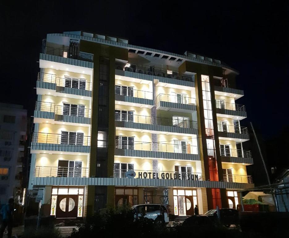 un edificio de hotel con un cartel en él por la noche en Ditto Room Hotel Golden Sun, New Digha en Digha