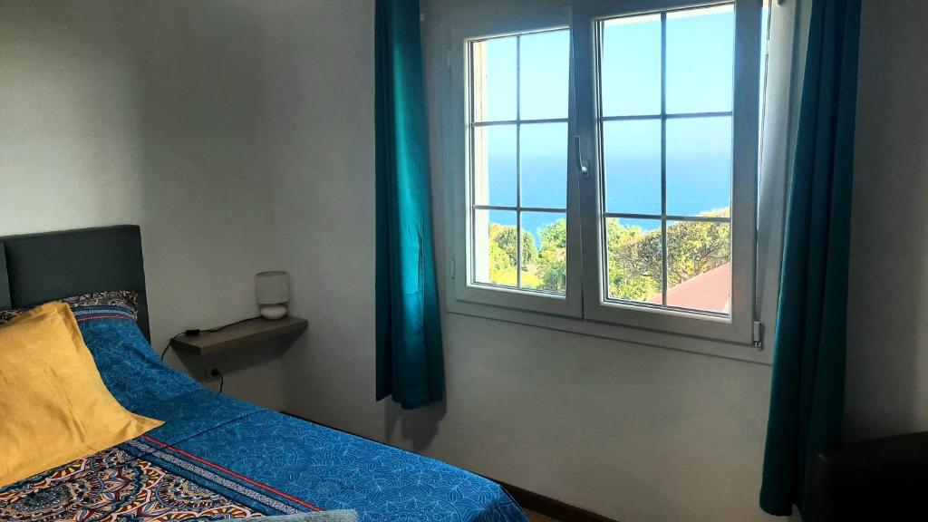 a bedroom with a bed and a window at Chambre vue sur mer entre Grande Anse et Manapany in Petite Île