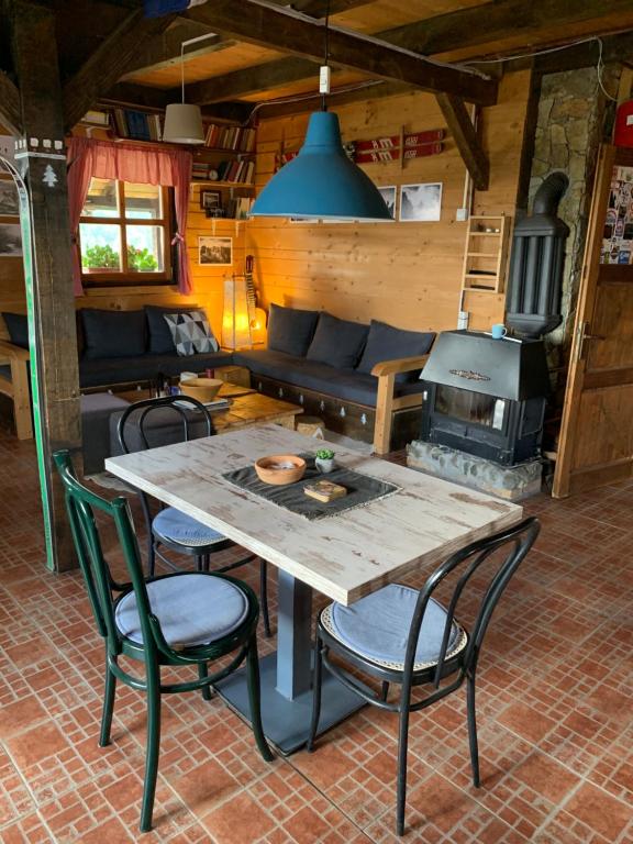 a table and chairs in a room with a stove at Planinarski dom "Tornik" Zlatibor in Ribnica