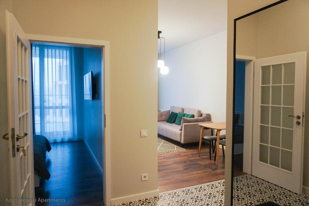 einen Flur mit einem Wohnzimmer mit Sofa und Spiegel in der Unterkunft Kostjukowski Apartments Forum in Lwiw