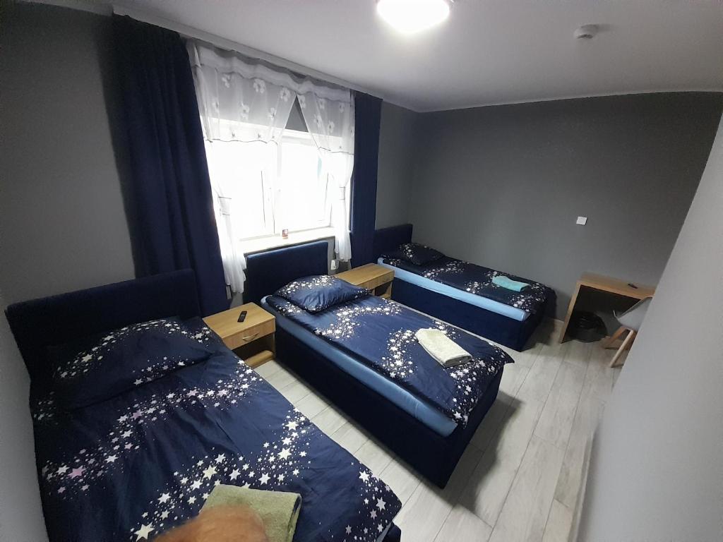 2 camas en una habitación pequeña con ventana en Szafir - NoclegiGrodziskPL, en Grodzisk Mazowiecki