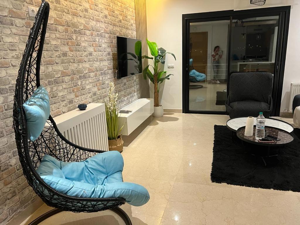 a rocking chair with blue cushions in a living room at Superbe Appartement kantaoui sousse in Sousse