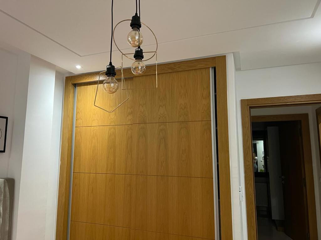a wooden garage door in a room with a chandelier at Superbe Appartement kantaoui sousse in Sousse