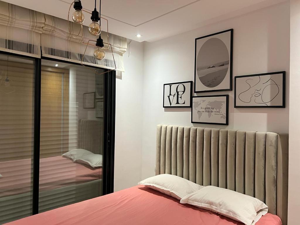 - une chambre dotée d'un lit avec des draps roses et un miroir dans l'établissement Superbe Appartement kantaoui sousse, à Sousse