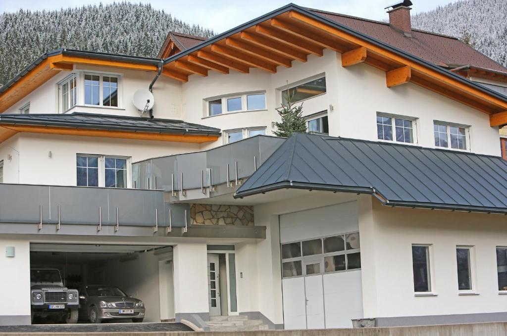 een wit huis met een zwart dak bij Zeilner Dachstein Apartment in Gosau