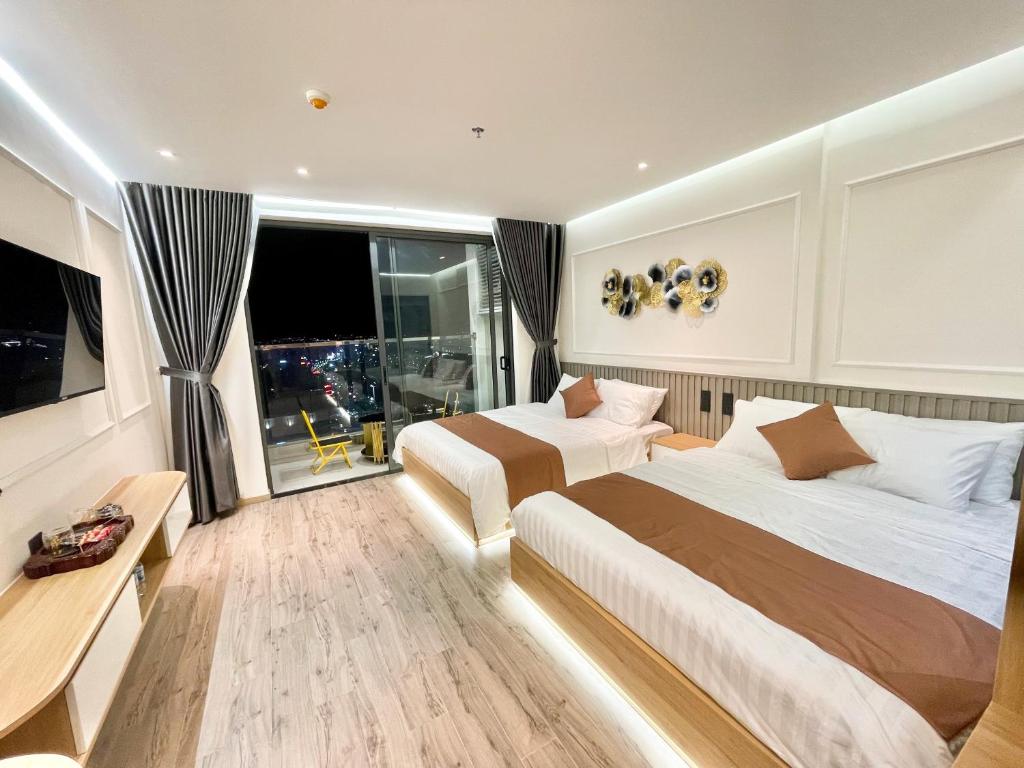 ein Hotelzimmer mit 2 Betten und einem Fenster in der Unterkunft Kings House Apec Condotel Phú Yên in Tuy Hoa