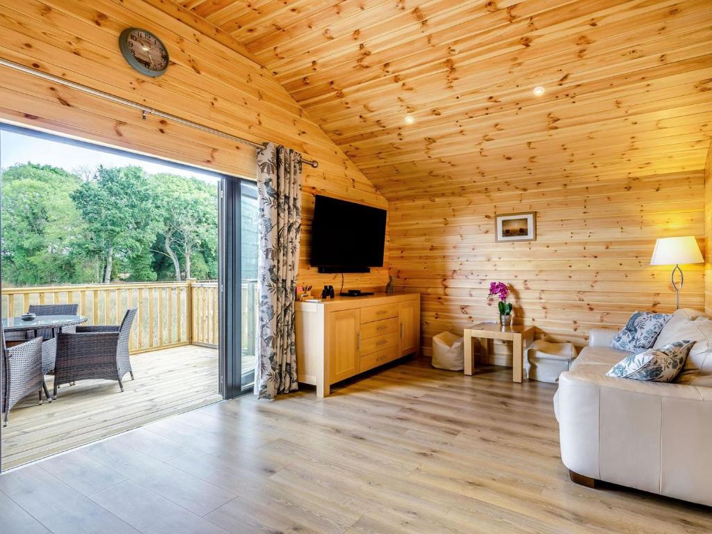 a living room with a couch and a television at Cabin Hideaways, Glencraig - Uk38359 in Mattishall