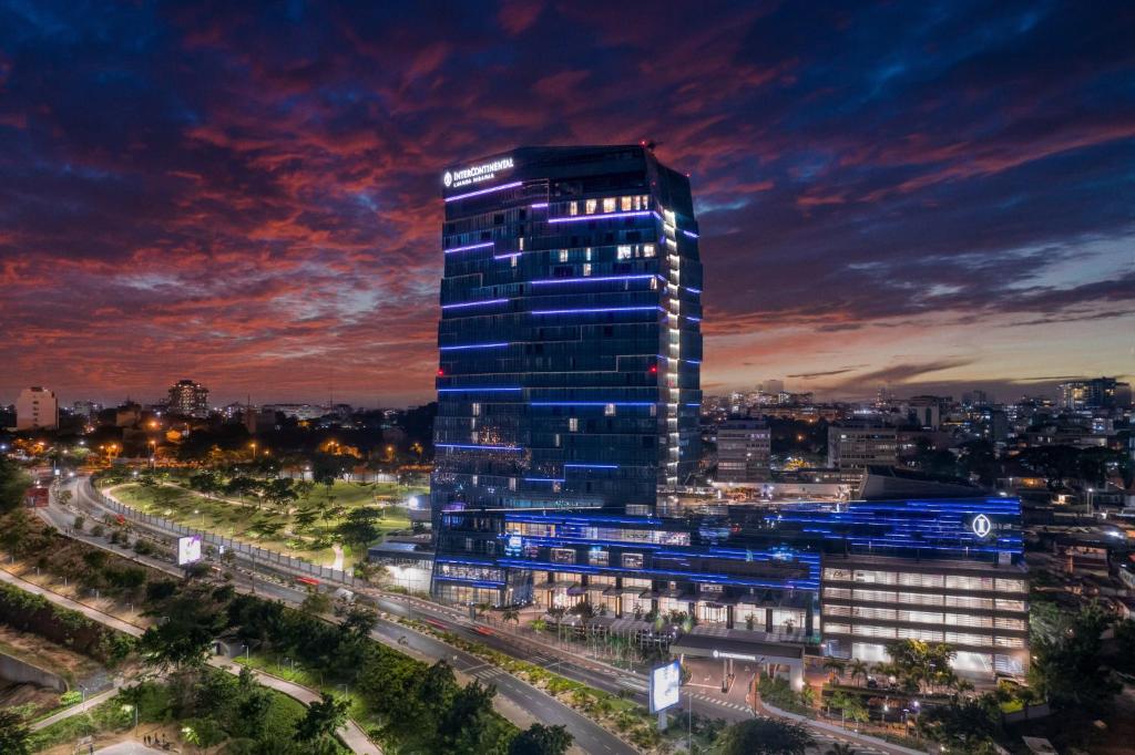 罗安达InterContinental Luanda Miramar by IHG的一座高大的建筑,晚上在城市里亮着灯