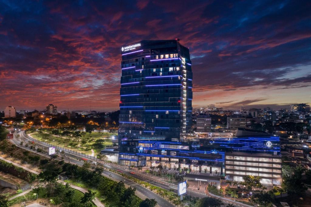 um edifício alto com luzes acesas numa cidade à noite em InterContinental Luanda Miramar, an IHG Hotel em Luanda