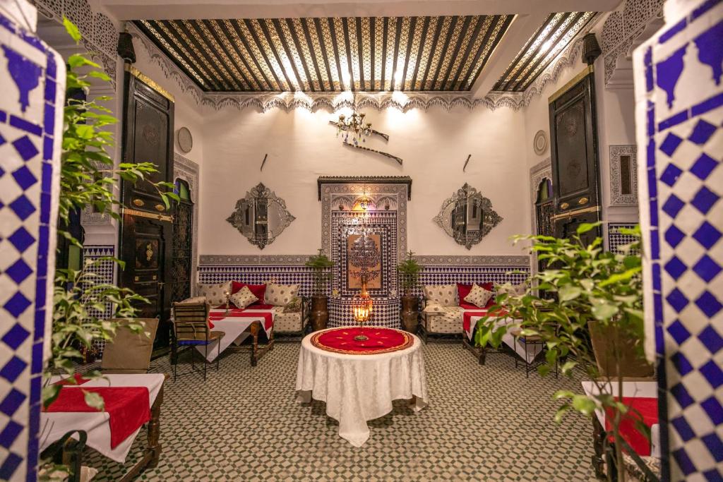 a room with a table and chairs and plants at DAR EL AAMOURI in Fez