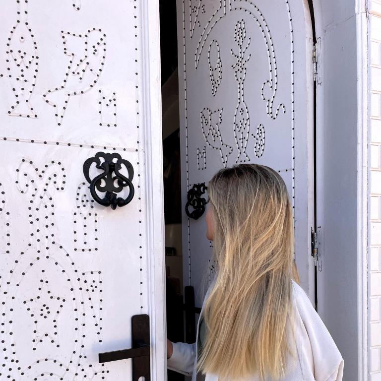 uma mulher está em pé em frente a uma porta em NUB INN em Aswan