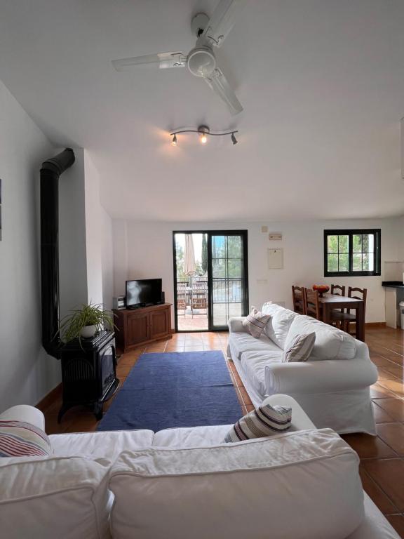 a living room with two white couches and a tv at Padre Aviles in Olías