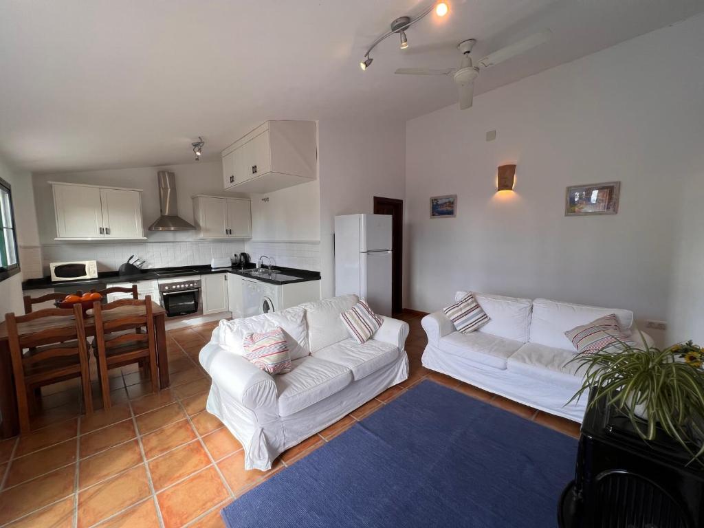 a living room with two white couches and a kitchen at Padre Aviles in Olías