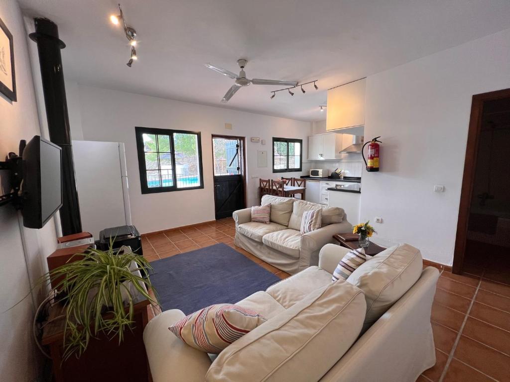 a living room with two couches and a kitchen at Padre Aviles in Olías