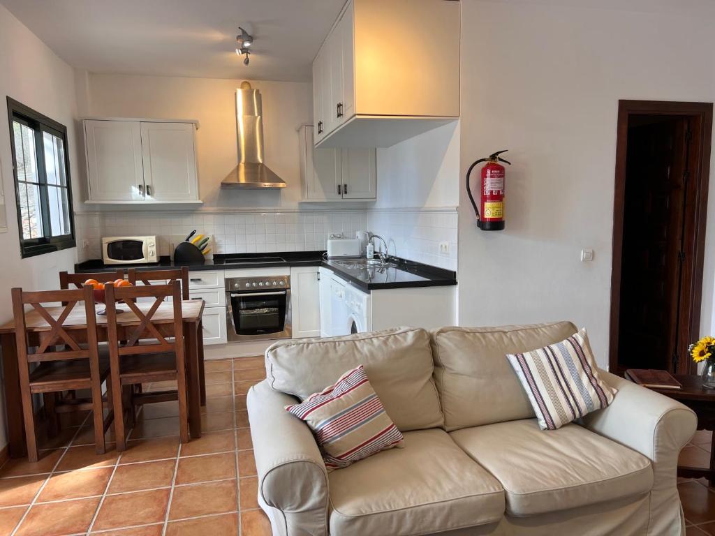 a living room with a couch and a kitchen at Padre Aviles in Olías