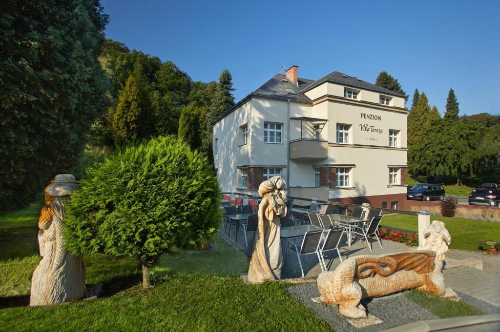 a hotel with statues in front of a building at Penzion Vila Tereza in Hranice