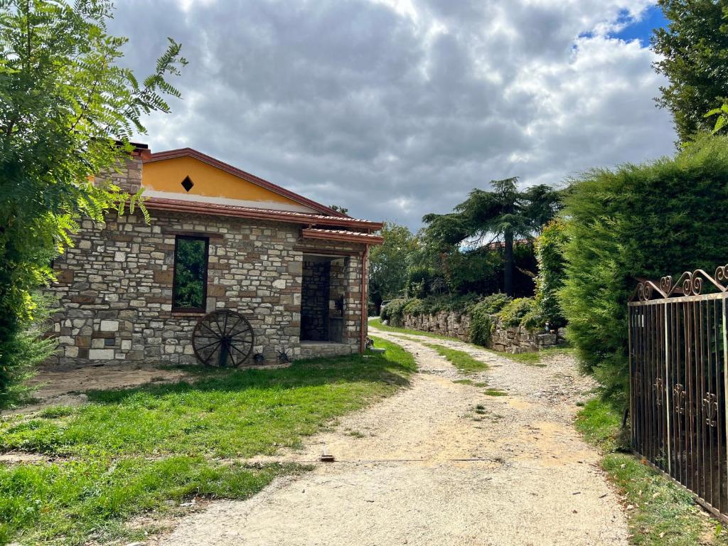 a stone house with a fence and a dirt road at Campo della Corte in Castelpagano