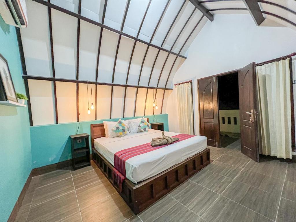 1 dormitorio con 1 cama grande en una habitación en Kidi's Lodge Gilitrawangan, en Gili Trawangan