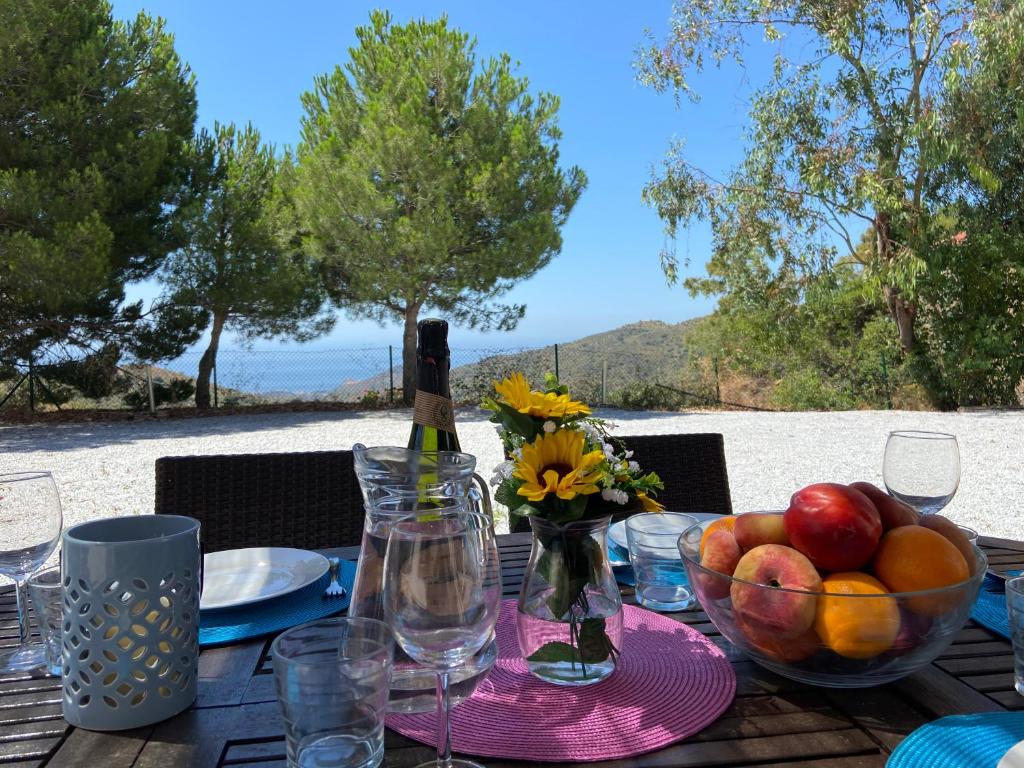 a table with a bowl of fruit and a bottle of wine at Padre Aviles in Olías