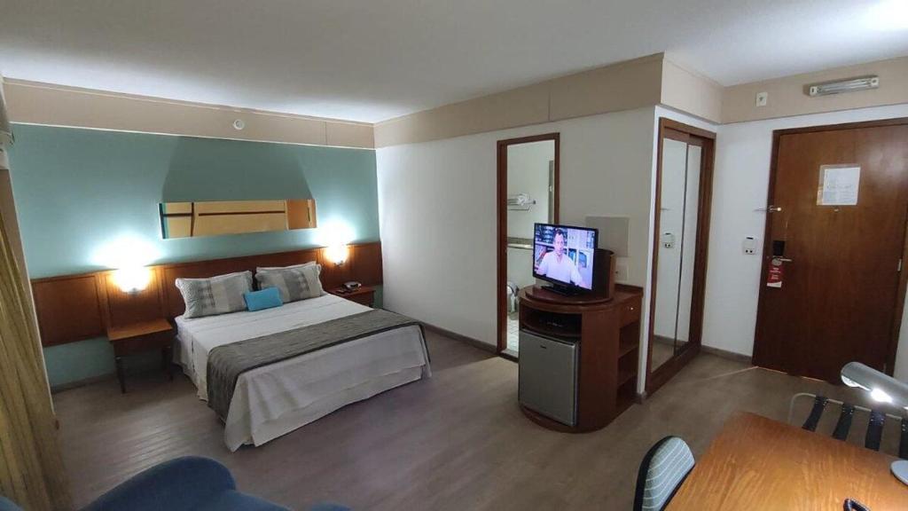 um quarto de hotel com uma cama e uma televisão em Flat Borges Lagoa Ibirapuera c/ garagem UH407 em São Paulo