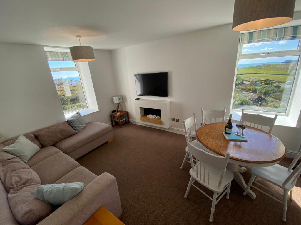 a living room with a couch and a table at Tudor Apartment (Panoramic Sea Views) in Trearddur