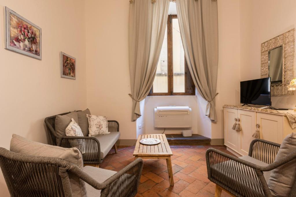 - un salon avec des chaises, une télévision et une table dans l'établissement Toscanella Romantic, à Florence