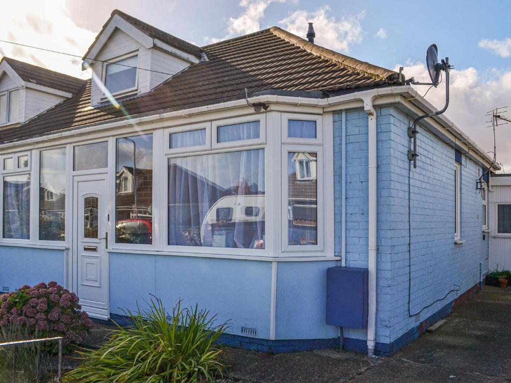 a blue house with a lot of windows at Joes Place in Mablethorpe
