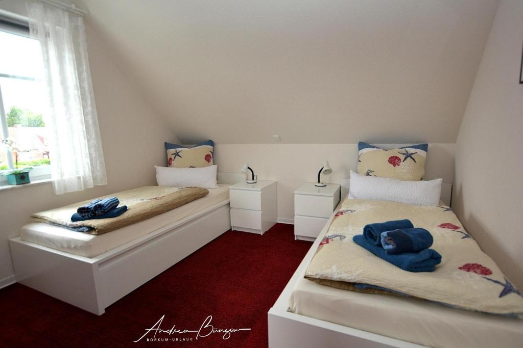 2 camas individuais num quarto com uma janela em Pension Lütje Huske Zimmer 3 em Südbrookmerland