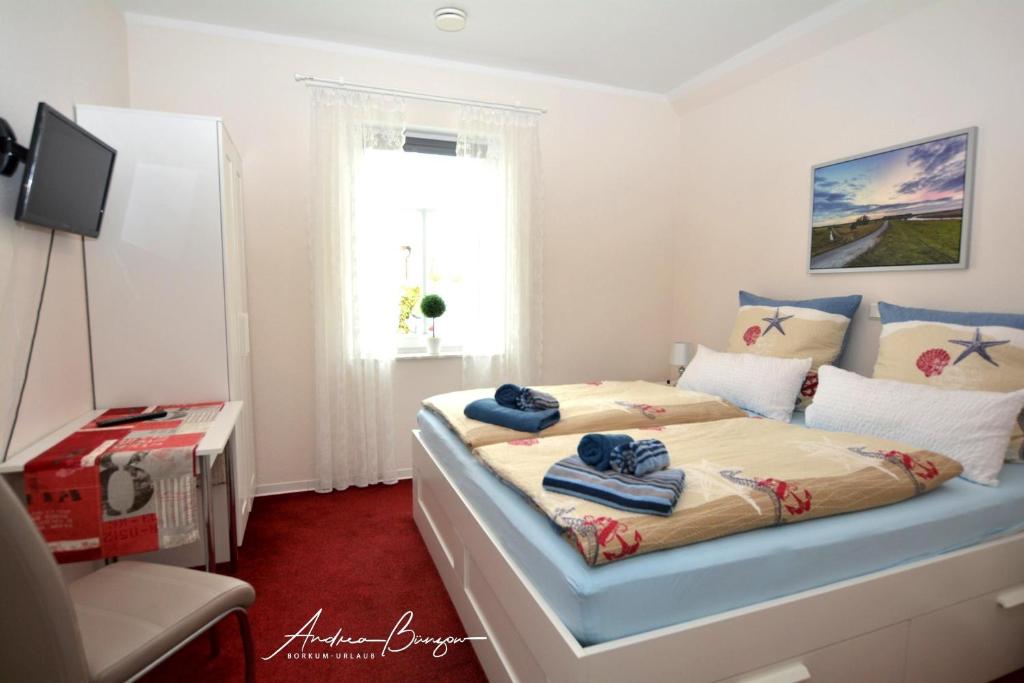 - une chambre avec un lit et des serviettes dans l'établissement Pension Lütje Huske Zimmer 1, à Südbrookmerland