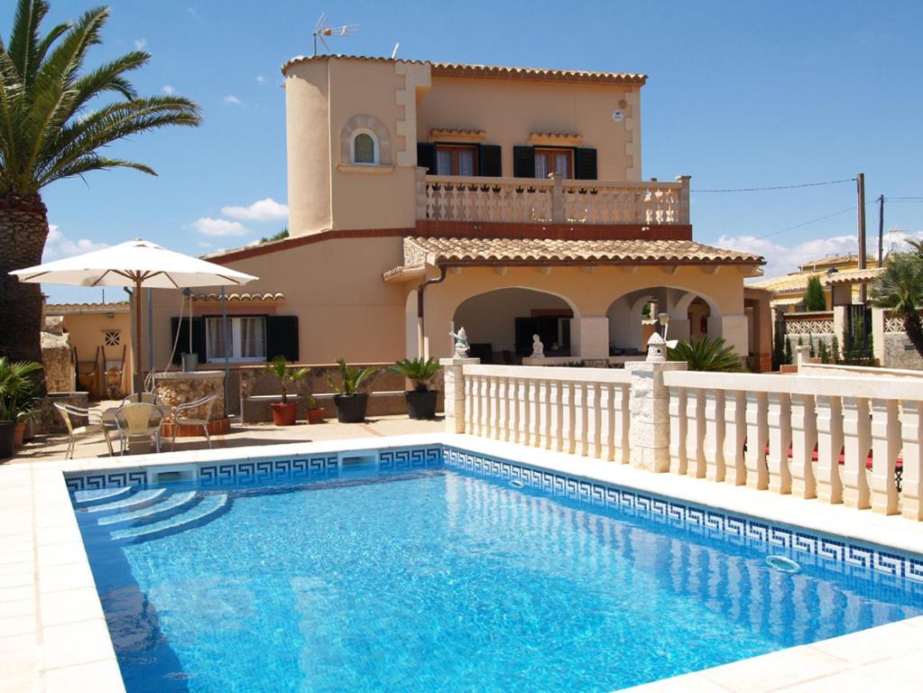 a villa with a swimming pool in front of a house at Villa López in Santanyi