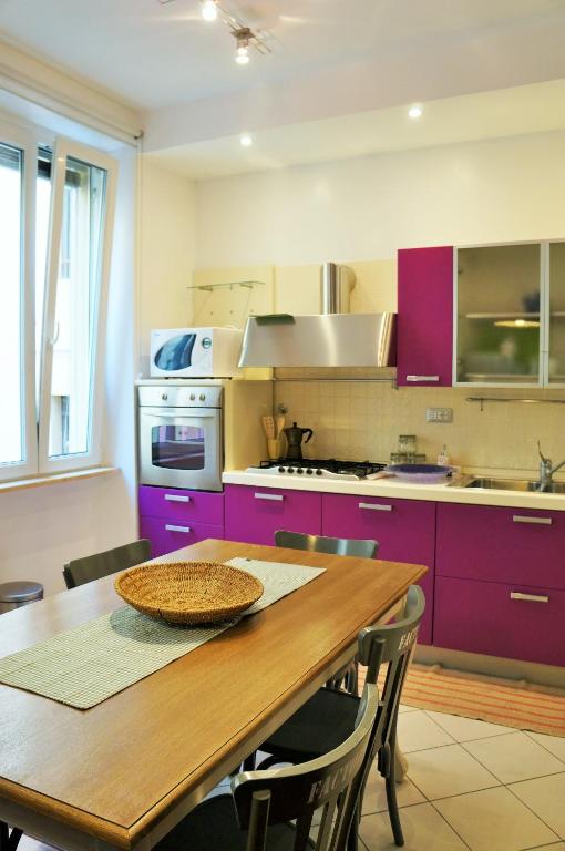 kuchnia z fioletowymi szafkami i drewnianym stołem w obiekcie A Casa Di Elle w Rzymie