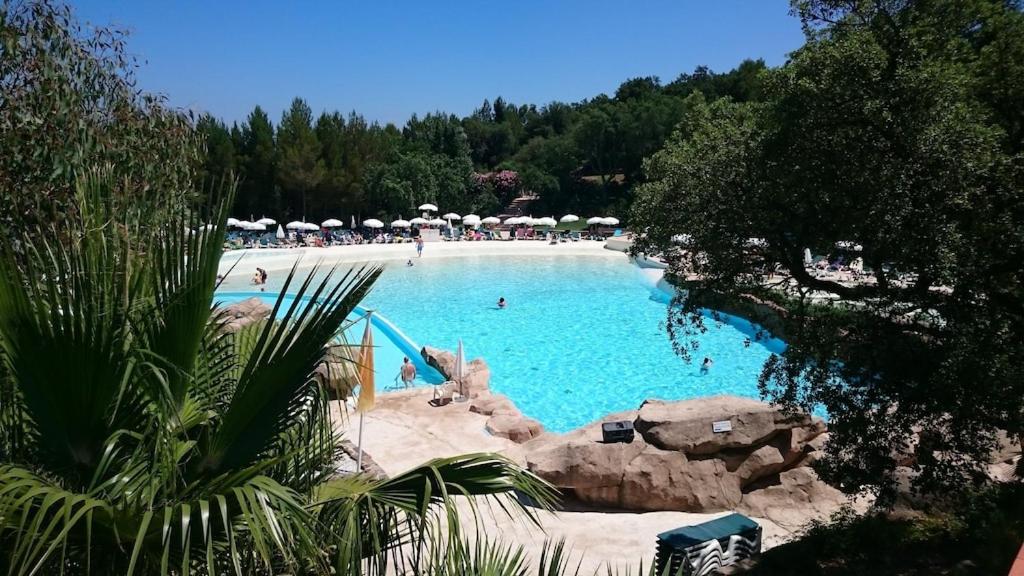 une grande piscine avec des gens dans un complexe hôtelier dans l'établissement Les Restanques 103 plein centre, à Grimaud