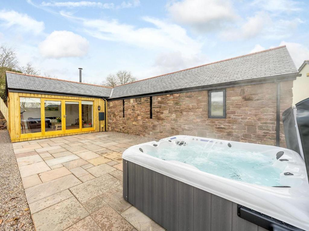 a hot tub in the backyard of a house at Tyr Ywen Cottage in Abergavenny