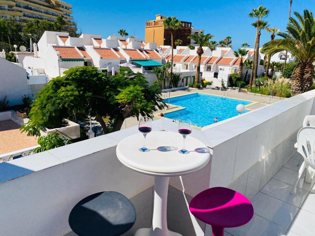 balcón con mesa y 2 copas de vino en Beach Bungalow Holiday Home, en Adeje