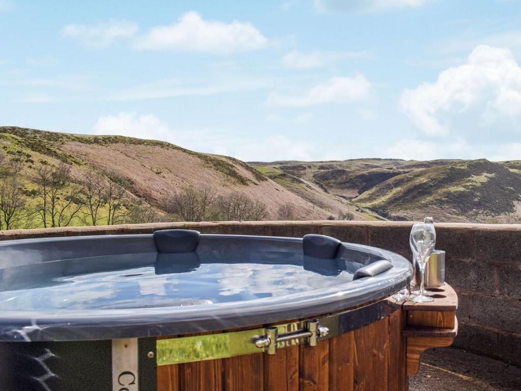 a jacuzzi tub with mountains in the background at Blaen Y Cwm in Carno