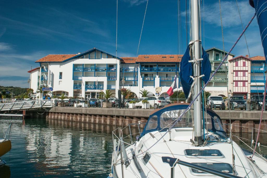 a boat docked in a marina with a building at Résidence Mer & Golf Sokoburu in Hendaye