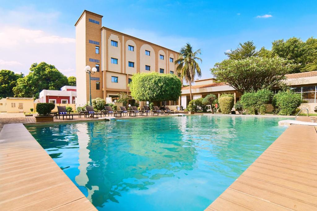 uma piscina em frente a um hotel em Dunia Hotel Bamako em Bamako
